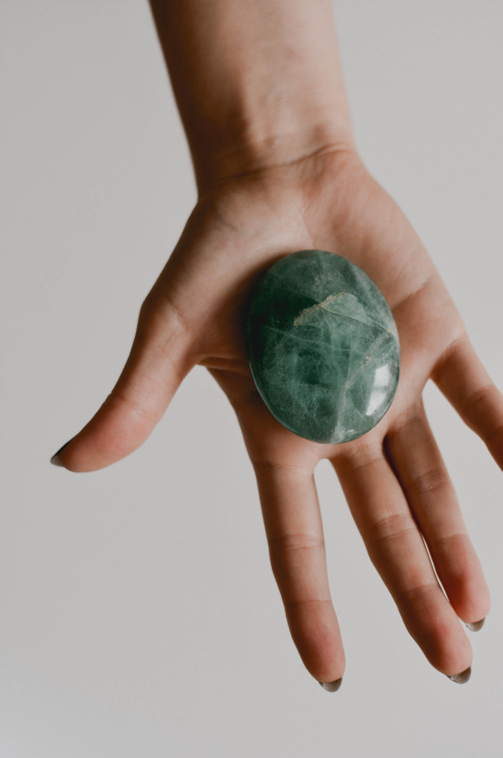 Hand holding a Green Fluorite crystal